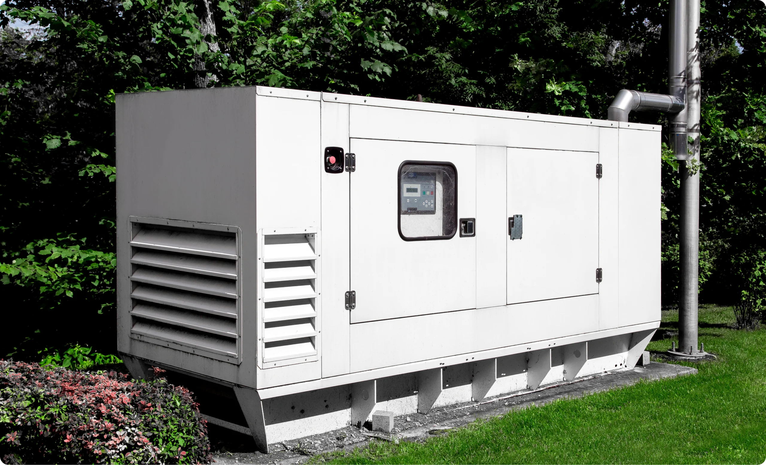 White standby generator enclosure installed beside a building